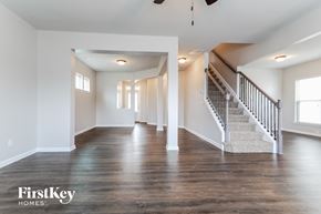 Lawrenceville house for rent - the family room and staircase of a new home with white walls and wood floors