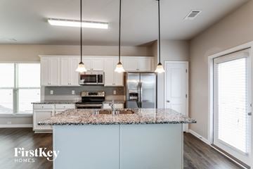 Lawrenceville house for rent - a kitchen with white cabinets and a granite counter top