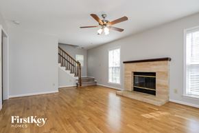 Charlotte house for rent - A spacious living room with a fireplace and a staircase.