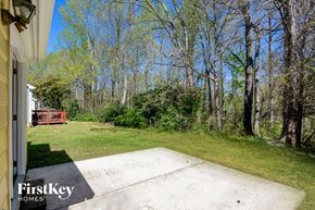 Charlotte house for rent - A backyard with a concrete slab and trees.
