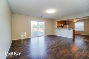 Columbus house for rent - the living room and kitchen of an empty house with wood flooring