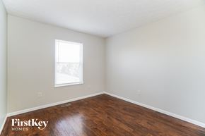 Columbus house for rent - a bedroom with wood floors and white walls and a window