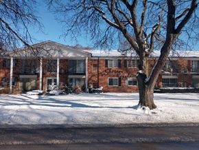 Royal Oak apartment for rent - a large brick building with a tree in the snow