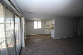 Royal Oak apartment for rent - an empty living room with a kitchen in the background
