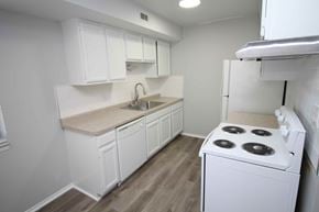 Royal Oak apartment for rent - a kitchen with white cabinets and a stove and refrigerator