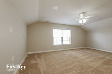 Indian Trail house for rent - a spacious living room with carpet and a ceiling fan