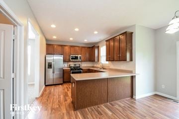 Zionsville house for rent - A kitchen with wooden cabinets and a refrigerator.