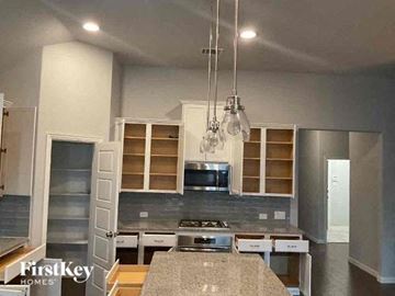 Celina house for rent - a kitchen with stainless steel appliances and white cabinets