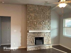 Celina house for rent - a stone fireplace in the corner of a living room