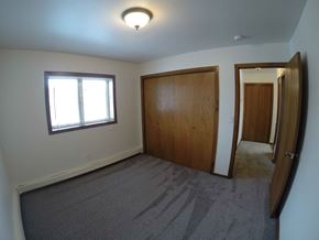 Fairbanks apartment for rent - A room with a carpeted floor, a window, and a wooden door.