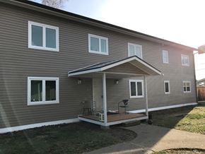 Fairbanks apartment for rent - A house with a grey siding and a white porch.