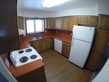 Fairbanks apartment for rent - A kitchen with a white fridge and a white stove top.