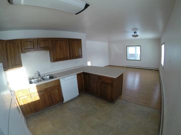 Fairbanks apartment for rent - A kitchen with wooden cabinets and a white dishwasher.