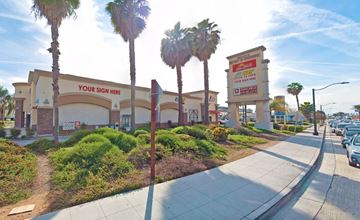 Commerce apartment for rent - A palm tree is in front of a store with a sign that says "Your Sign Here".
