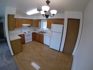 Fairbanks apartment for rent - A kitchen with wooden cabinets and white appliances.