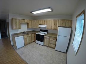 Fairbanks apartment for rent - A kitchen with wooden cabinets and white appliances.