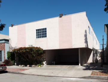 Canoga Park apartment for rent - A white and pink building with a window and a garage door.