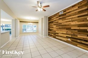 Wesley Chapel house for rent - a dining room with a wood wall and a ceiling fan