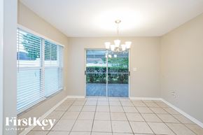 Wesley Chapel house for rent - an empty dining room with a large window and a chandelier
