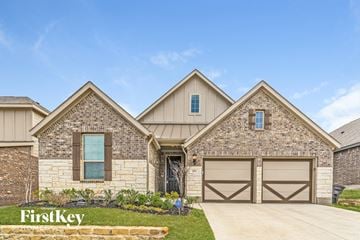 Fort Worth house for rent - exterior of a home with stone and wood garage doors
