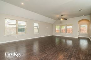 Fort Worth house for rent - an empty living room with wood floors and a ceiling fan