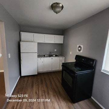 Cincinnati apartment for rent - A kitchen with a black stove top oven and white appliances.