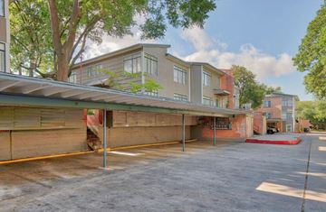 San Antonio apartment for rent - A parking lot in front of a building with a red awning.