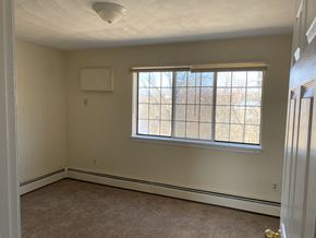 West Warwick apartment for rent - a bedroom with a large window and a carpeted floor
