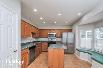 Riverview house for rent - A kitchen with wooden cabinets and a refrigerator.