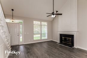 Huntersville house for rent - a living room with a fireplace and a ceiling fan