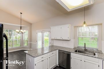 Huntersville house for rent - a kitchen with white cabinets and a granite counter top