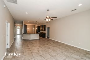 Jacksonville house for rent - A spacious room with a ceiling fan and tiled flooring.