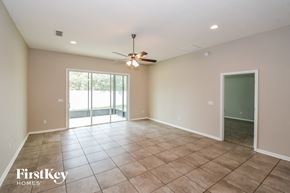 Jacksonville house for rent - A spacious room with a ceiling fan and sliding glass doors leading to a balcony.