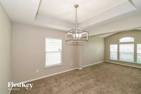 Jacksonville house for rent - A spacious room with a carpeted floor and a chandelier hanging from the ceiling.