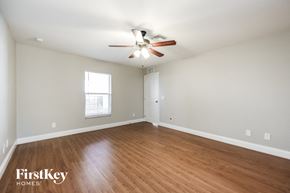 Lehigh Acres house for rent - a living room with wood flooring and a ceiling fan