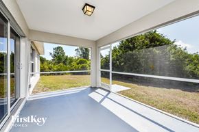 Lehigh Acres house for rent - A sunny balcony with a view of trees and grass.