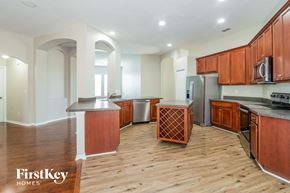 Orange Park house for rent - a kitchen with wood flooring and wooden cabinets and stainless steel appliances