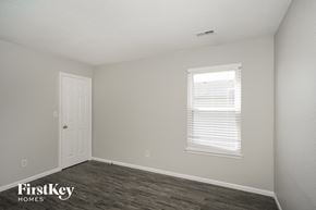 Franklin house for rent - a bedroom with a white door and a window and a wood floor