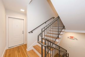 Cambridge apartment for rent - a staircase in a home with a white door and wood floors