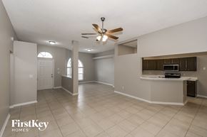 Jacksonville house for rent - an empty kitchen and living room with a ceiling fan