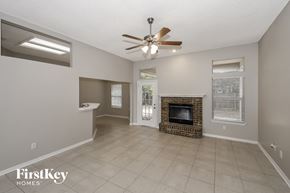 Jacksonville house for rent - a living room with a fireplace and a ceiling fan