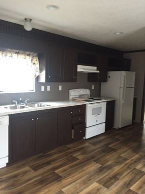 Houston apartment for rent - an empty kitchen with white appliances and dark cabinets