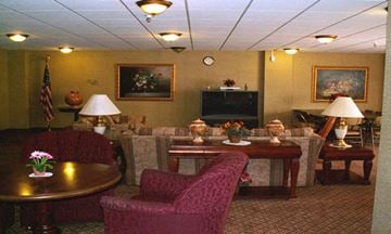 Anoka apartment for rent - A living room with a red chair and a brown table.