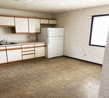 Hutchinson apartment for rent - A kitchen with a white refrigerator and brown cabinets.