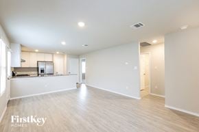 Converse house for rent - A spacious empty room with wooden flooring and white walls.