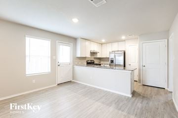 Converse house for rent - A kitchen area with a refrigerator, microwave, and oven.