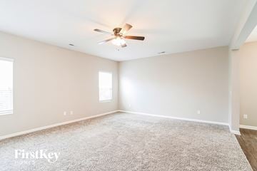 Midland house for rent - a spacious living room with a ceiling fan and carpet