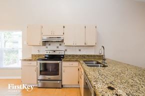 Brandon house for rent - a kitchen with granite counter tops and white cabinets