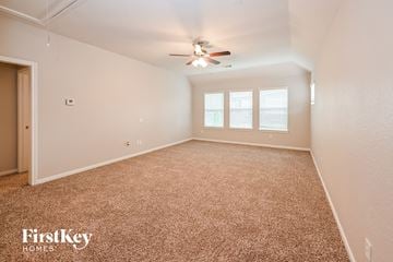 Humble house for rent - a spacious living room with carpet and a ceiling fan