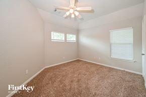 Humble house for rent - the master bedroom has a ceiling fan and beige carpet